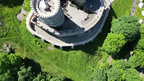 Medieval-Bedzin-castle-with-a-turret,-walls,-and-courtyard-during-a-beautiful-summer-day-surrounded-by-lush-greenery,-grass,-and-trees