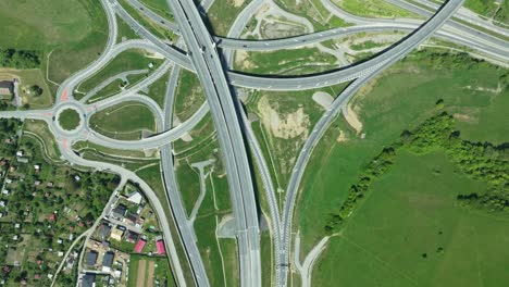An-aerial-drone-footage-captures-intricate-highway-junction-with-cars-navigating-complex-roundabouts-and-intersecting-roads