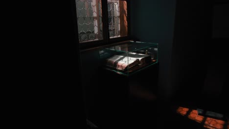 Dimly-lit-Prayer-Room-in-Trakošćan-Castle-,-Croatia,-featuring-an-open-book-in-a-glass-display-case