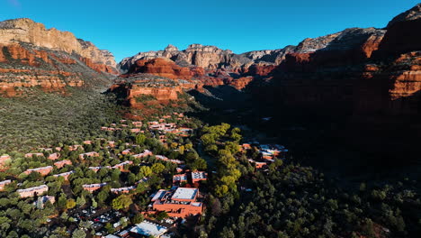 Resort-Town-With-Dense-Vegetation-Down-Red-Rock-Mountains-In-Sedona,-Arizona,-USA