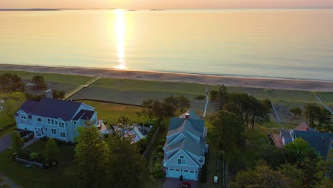 Sonnenaufgang-über-Strandhäusern-Mit-Farben,-Die-Sich-In-Den-Meereswellen-Spiegeln,-Und-Ferienhäusern-Entlang-Der-Atlantikküste-Von-Neuengland