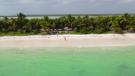 Aerial-view-of-the-waves-sea-touching-the-girl's-feet-on-the-beach-of-Sian-ka'an