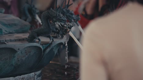 Closeup-Of-Black-Dragon-Fountain-With-People-In-Tokyo,-Japan