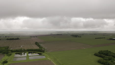 Eine-Drohne-Bewegt-Sich-Durch-Die-Wolken-über-Grasland-Und-Ackerland-Im-Mittleren-Westen-Der-USA