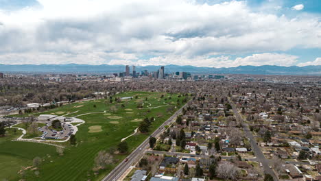 Trucking-aerial-hyperlapse-over-Denver-city-park-with-view-of-skyline-in-back