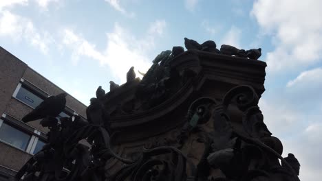 Many-pigeons-sitting-on-a-historic-statue-in-german-town-Nuremberg