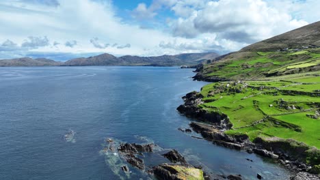 Drone-gliding-along-the-wild-remote-coastline-of-West-Cork-Ireland,dramatic-wild-beauty-with-the-mountains-of-Cods-Head-Peninsula-in-the-background-on-a-bright-summer-day