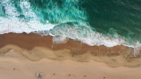Overhead-View-of-Foamy-White-Waves-Crashing-On-The-Sandy-Shore-Of-Beach