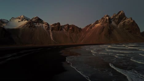 Playa-De-Islandia-Con-Olas-Del-Océano-Y-Fondo-Montañoso-Desde-Un-Dron-Aéreo