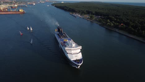 Huge-DFDS-ferry-leaving-Klaipeda-harbor,-aerial-fly-over-view