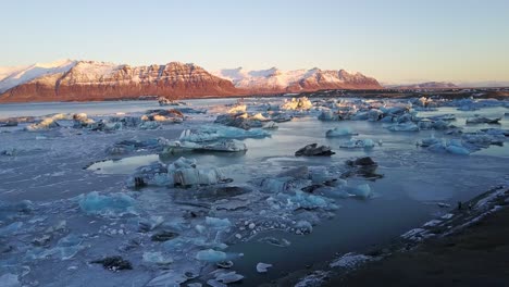 Icebergs-Flotando-En-Un-Lago-Con-Fondo-Montañoso