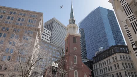 Spaziergang-Durch-Die-Straßen-Der-Innenstadt-Von-Boston-Mit-Blick-Auf-Den-Kirchturm-Und-Vögel,-Die-Darüber-Fliegen