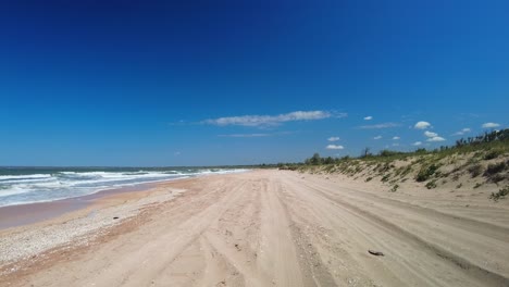 Playa-Vacía-Con-El-Telón-De-Fondo-De-Cielo-Azul-Y-Mar-Salvaje