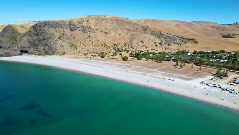 Drone-shot-moving-backwards-and-curving-around-to-reveal-a-campsite-on-Rapid-Bay,-a-popular-campsite-in-South-Australia