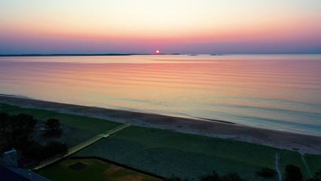 Luftaufnahme-Eines-Wunderschönen-Sonnenaufgangs-Am-Strand-In-Saco,-Maine,-Mit-Farben,-Die-Sich-In-Den-Meereswellen-Widerspiegeln,-Und-Ferienhäusern-Entlang-Der-Atlantikküste-Von-Neuengland