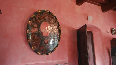 Baroque-Room-in-Trakošćan-Castle,-showcasing-an-ornate-oval-mirror-on-a-pink-wall