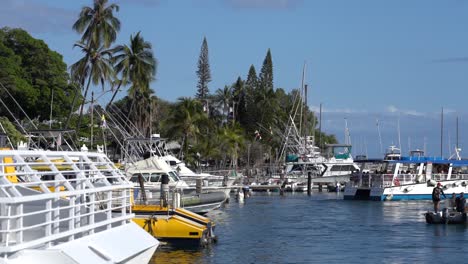 Sailboats-and-powerboats-moor-in-Lahaina-harbor-in-Lahaina,-Maui,-Hawaii-as-a-small-boat-leaves-the-harbor