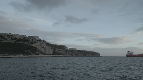 Una-Toma-Panorámica-De-4k-Sobre-El-Mar-En-El-Estrecho-De-Gibraltar,-Panorámica-Desde-Algeciras-España,-Mirando-Más-Allá-De-áfrica-Y-Hacia-La-Bahía-De-Rosia-En-Gibraltar-En-Un-Día-Nublado