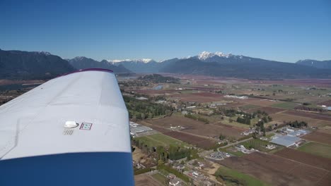 Piper-PA28-In-Flight,-Pilot's-View-of-Wing-and-Sunny-Mountain-Scenery