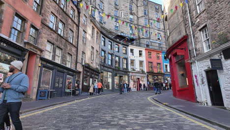 Slowmotion-dolly-view-of-tourists-walking-on-the-Victoria-Street-in-Edinburgh-on-a-sunny-day