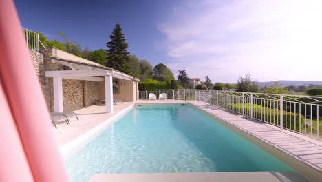 Slow-establishing-shot-of-a-turquoise-private-pool-at-a-villa-in-Tresques,-France