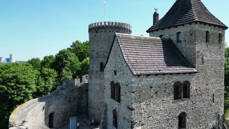 Castillo-Medieval-De-Bedzin-Con-Torreta,-Paredes-De-Piedra-Y-Patio-Durante-Un-Hermoso-Día-De-Verano-Rodeado-De-Exuberante-Vegetación,-Bajo-Un-Cielo-Azul-Claro