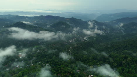 Vista-Aérea-Lejana-De-Una-Densa-Selva-Tropical,-Montañas-De-Vegetación-Y-Nubes-Brumosas,-Vistas-Reales-De-Munnar,-Kerala,-India.