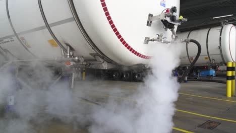 External-fuel-tank-is-cleaned-with-hot-water-emitting-steam,-close-up