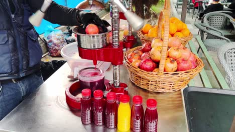 Juicer-man-selling-his-fruit-stall-to-make-a-fresh-pomegranate-juice-with-squeeze-machine-4k