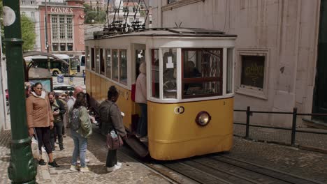 Shot-of-tourists-and-local-people-taking-tram-on-a-sunny-day-in-Lisbon,-Portugal