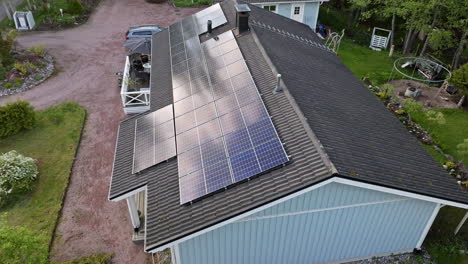 Luftbildübersicht-über-Spiegelnde-Solarmodule-Auf-Dem-Dach-Eines-Einfamilienhauses,-Sommertag