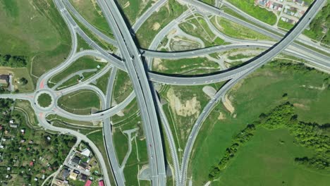 An-aerial-drone-footage-captures-intricate-highway-junction-with-cars-navigating-complex-roundabouts-and-intersecting-roads