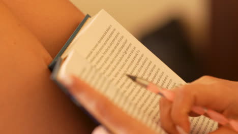 A-close-up-of-an-open-book-with-pages-slightly-fanned,-held-by-a-person-with-blurred-background