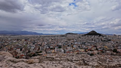 Panoramic-view-of-Athens-city-with-Mount-Lycabettus-on-cloudy-day,-panning-view