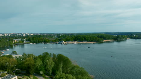 Ein-Panoramablick-Auf-Den-Ukiel-See-In-Olsztyn-Mit-Einer-Mischung-Aus-Stadtentwicklung-Und-üppigem-Grün-Entlang-Der-Uferlinie