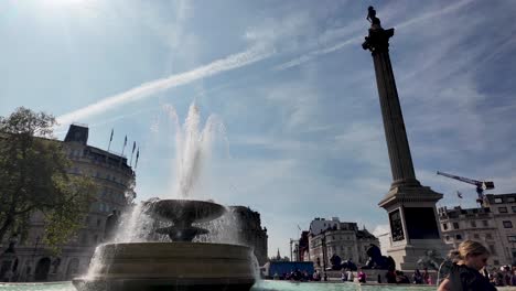 Día-Soleado-En-Trafalgar-Square-Con-Turistas-Disfrutando-De-La-Fuente-Y-La-Columna-De-Nelson-Al-Fondo