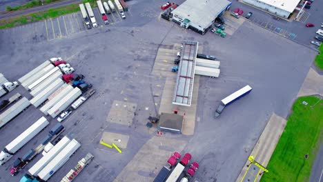 Aerial-view-of-a-truck-stop-fuel-island-in-PA,-busy-with-semi-trucks-refueling