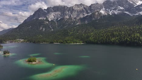 Antena-Sobre-Eibsee,-Grainau,-Alemania,-Contra-Un-Impresionante-Telón-De-Fondo-Montañoso