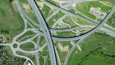 Aerial-static-drone-footage-capturing-intricate-highway-junction-with-cars-navigating-complex-roundabouts-and-intersecting-roads-with-cars