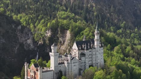 Aerial-Dolly-Out-of-Beautiful-White-Castle-Tucked-into-Green-Mountaintop-Forest
