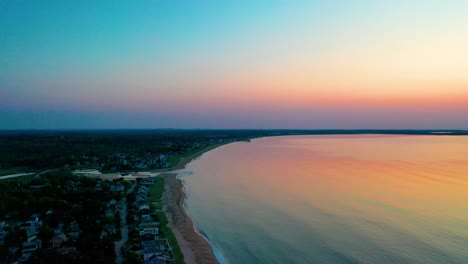 Wunderschöner-Sonnenaufgang-Am-Strand-In-Saco,-Maine,-Mit-Farben,-Die-Sich-In-Den-Meereswellen-Spiegeln,-Und-Ferienhäusern-Entlang-Der-Atlantikküste-Von-Neuengland
