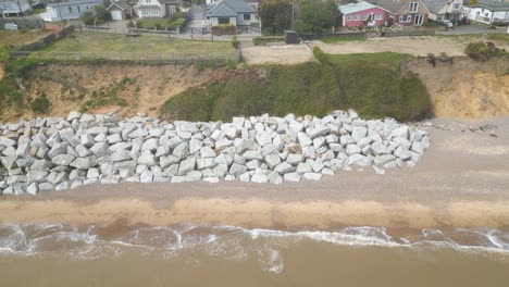 Drone-view-of-stones-kept-at-shore-of-Pakefield-Beach-in-Lowestoft,-England