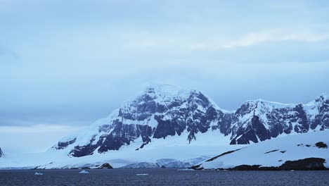 Paisaje-De-Montañas-Invernales-Con-Nieve-Y-Hielo,-Hermoso-Y-Espectacular-Paisaje-Azul-En-La-Antártida-En-La-Península-Antártica,-Condiciones-Climáticas-Frías-Con-Grandes-Montañas
