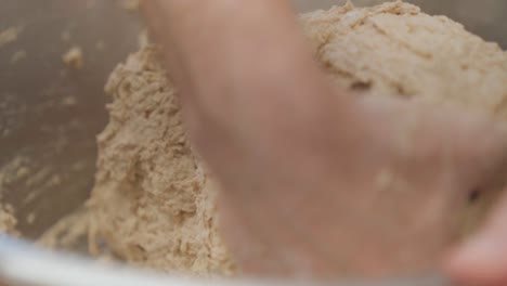 Sourdough-bread-dough-kneading-in-a-bowl,-closeup-on-hands