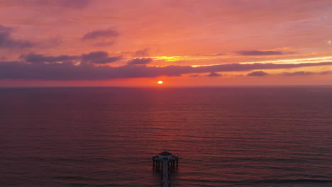 Cielo-Vibrante-Durante-La-Puesta-De-Sol-En-El-Muelle-De-Manhattan-Beach-Junto-Al-Mar-En-Calma-En-California,-Estados-Unidos