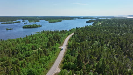 Drone-rotating-away-from-a-RV-driving-in-middle-of-lakes-and-islands-in-the-polar-wild