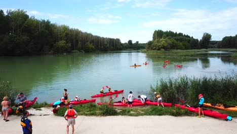 Aerial-shot-of-people-leaving-by-kayak-on-Danube-river,-Hungary,-on-a-sunny-day