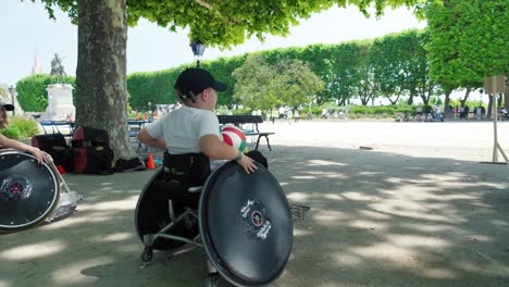 Slow-motion-shot-of-disabled-children-playing-sports-in-a-wheelchair-in-a-park
