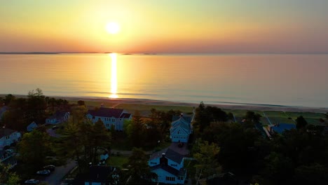 Sonnenuntergang-über-Einem-Strandhaus-In-Saco,-Maine,-Mit-Farben,-Die-Sich-In-Den-Meereswellen-Spiegeln,-Und-Ferienhäusern-Entlang-Der-Atlantikküste-Von-Neuengland