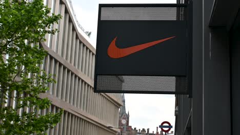 Nike-logo-held-before-St-Pancras-Hotel-and-Underground-Station,-London,-United-Kingdom